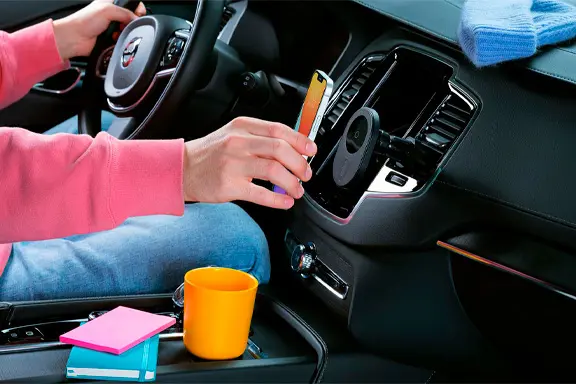 O iPhone carrega por indução no carro através de um suporte nas aberturas de ventilação.