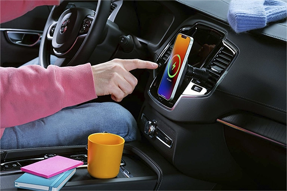 O telemóvel carrega no suporte MagSafe de um veículo, fixo nas aberturas de ventilação.