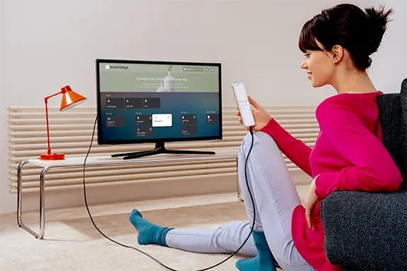 Vídeos e fotografias de telemóveis são partilhados no televisor através de um cabo USB.