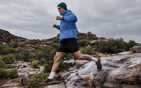 Um homem corre por terreno pedregoso e usa um smartwatch Hama